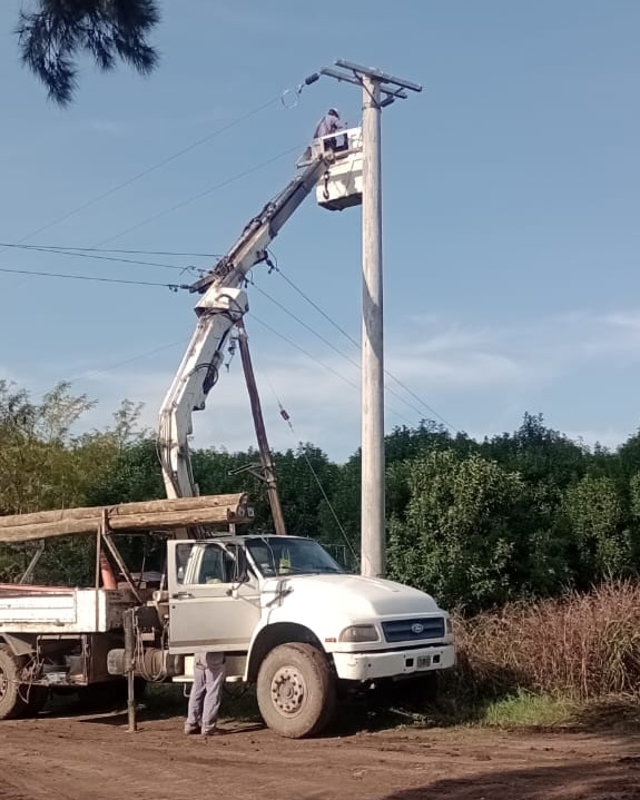 Hidrogrúa trabajando sobre un poste eléctrico junto al camión