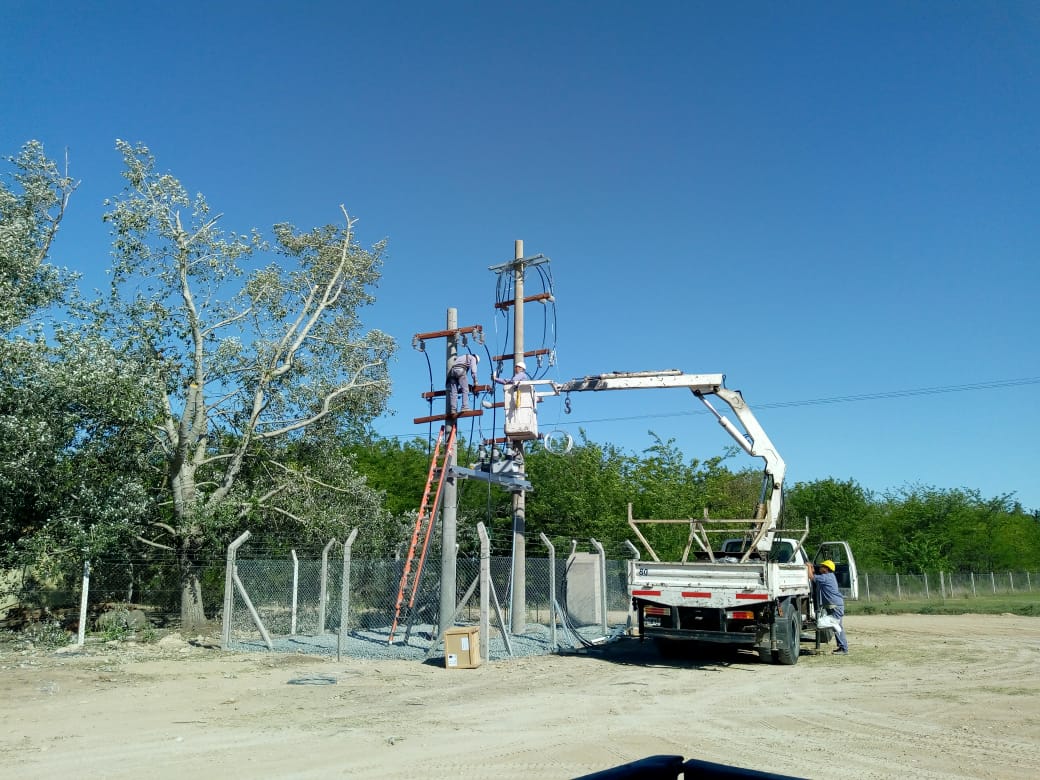Equipo de trabajo instalando una estructura eléctrica con hidrogrúa